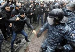 epa03964630 Ukrainian protesters clash with riot police near of the Cabinet of Ministers building during a protest in downtown Kiev, Ukraine, 25 November 2013. The ongoing pro-European protests in Ukraine threatened to turn violent when scuffles broke out between police and protesters outside a government building in Kiev. The protesters have been active all night in the centre of the Ukrainian capital, where they erected tents around European Square. Protesters demanded that the government roll back last week's decision to suspend work on a landmark association agreement with the European Union, calling for President Viktor Yanukovych to sign the deal.  EPA/SERGEY DOLZHENKO