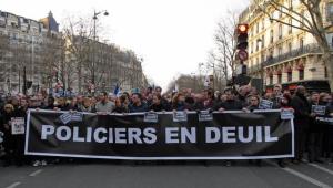 Un momento della marcia di Parigi dell'11 gennaio. La scritta sullo striscione: poliziotti in lutto. Foto Ansa