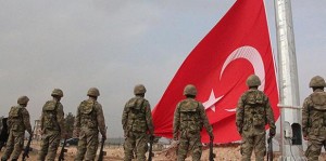 Soldati turchi issano la bandiera con la mezzaluna e la stella sul valico di Mür?itp?nar, distretto di Suruç. Una bandiera di enormi dimensioni, ben visibili da Kobane