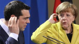 epa04676338 German Chancellor Angela Merkel (R) and Greek Prime Minister Alexis Tsipras (L) adjust their earpiece as they inform the public about their previous talk during a press conference in the Federal Chancellery in Berlin, Germany, 23 March 2015. Tsipras is expected to present a list of reforms, hoping to unlock bailout funds to prevent Greece from running out of cash next month, Greek government sources said.  EPA/STEPHANIE PILICK