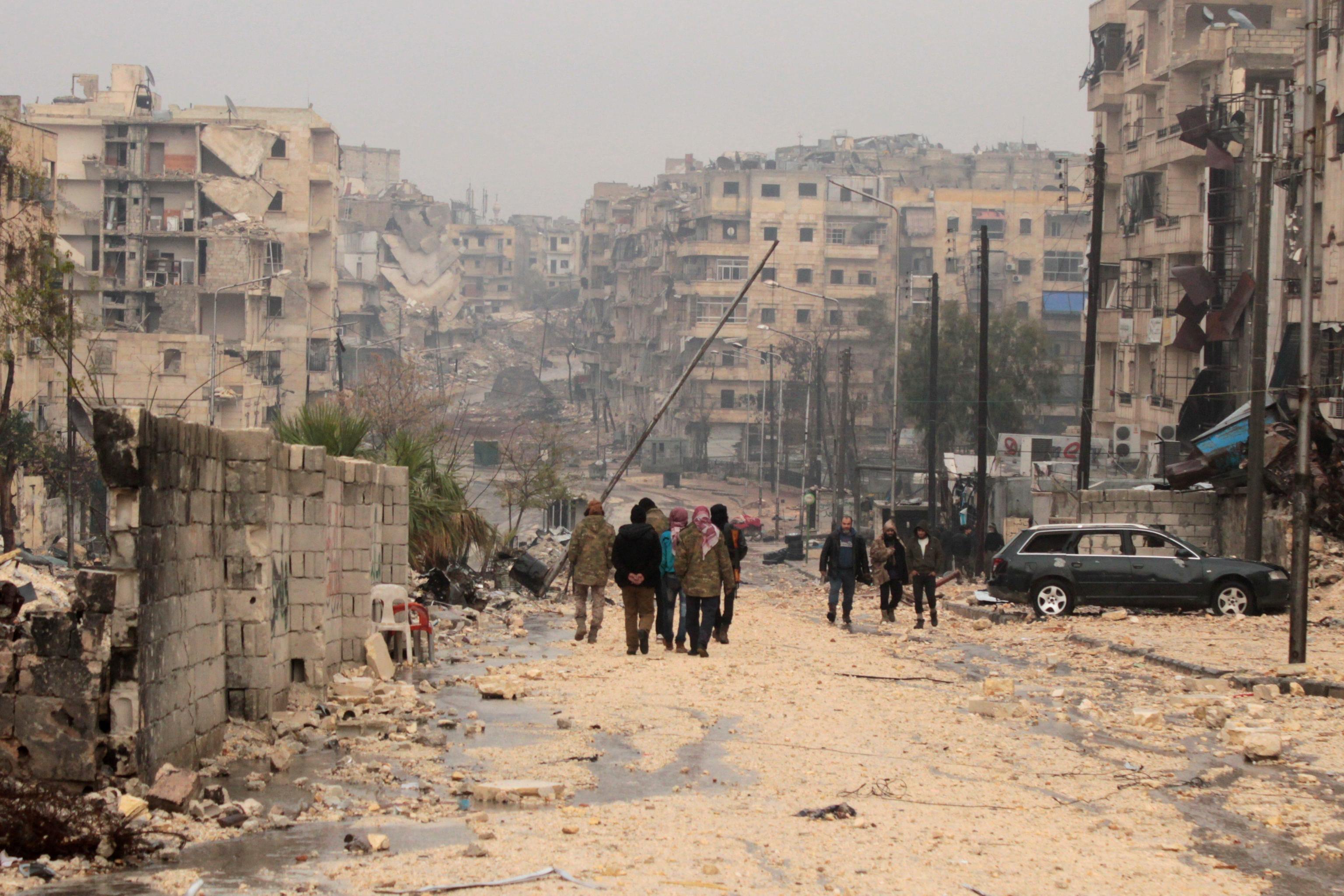 People walk at a damaged area one day after a ceasefire was announced, at al-Mashhad neighborhood in the rebel-held part of Aleppo, Syria, 14 December 2016. Syrian Observatory for Human Rights said fighting erupted around the final rebel-held area of Aleppo on 14 December as the scheduled ceasefire and mass evacuation of opposition fighters from the area stalled. ANSA/STRINGER