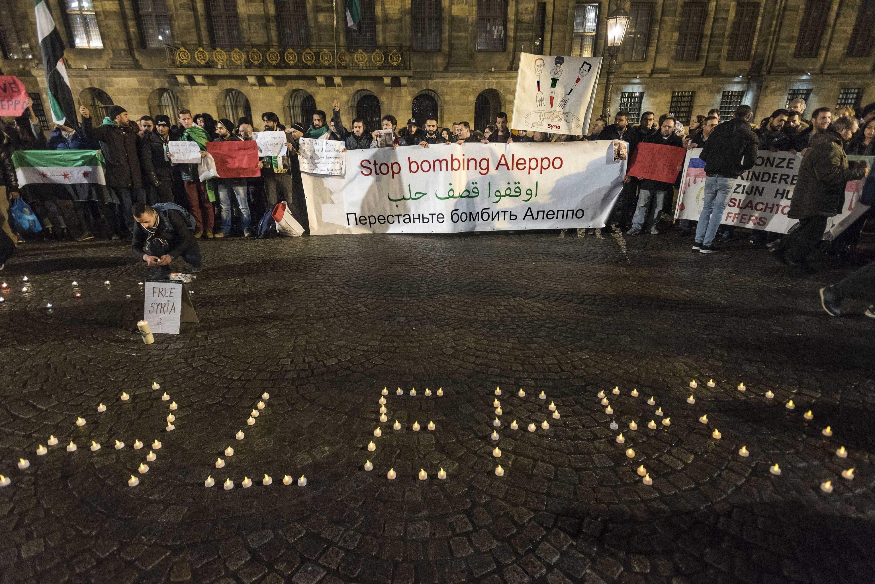 epaselect epa05675862 A candlelight vigil for the victims of the fighting in Aleppo is held in Dam Square in Amsterdam, The Netherlands, 14 December 2016. EPA/Evert Elzinga