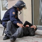 Spagna, un poliziotto assiste un manifestante