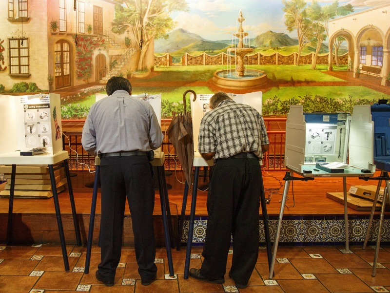 Gli elettori votano per le elezioni presidenziali degli Stati Uniti 2016 sotto un murales raffigurante il Messico rurale nel seggio posto nel ristorante El Mercadito Mariachi a Los Angeles, California.