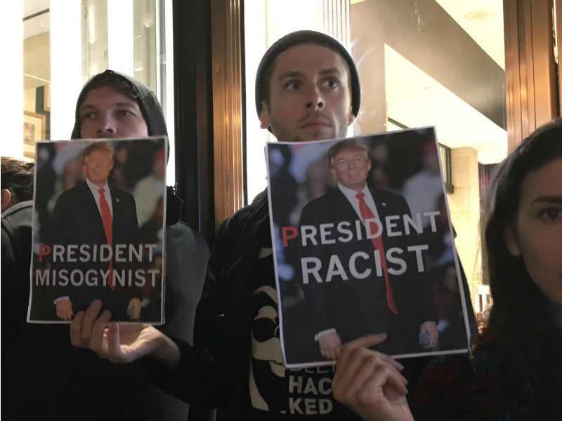 Ragazzi con cartelli che accusano Trump di misoginia e razzismo