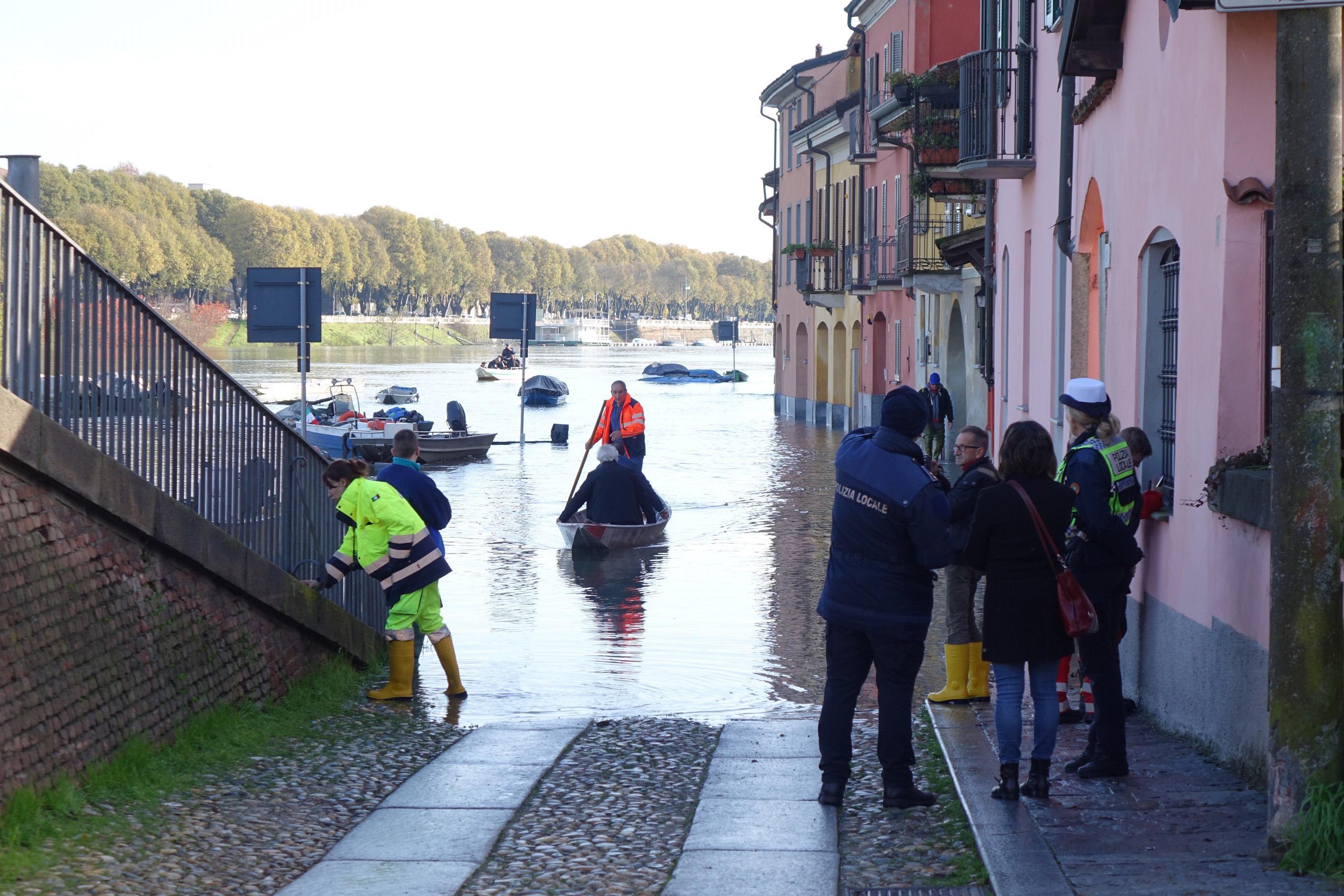Volontari della Protezione Civile aiutano i cittadini di Pavia ad uscire dalle case allagate (foto Ansa/ Dino Ferretti)