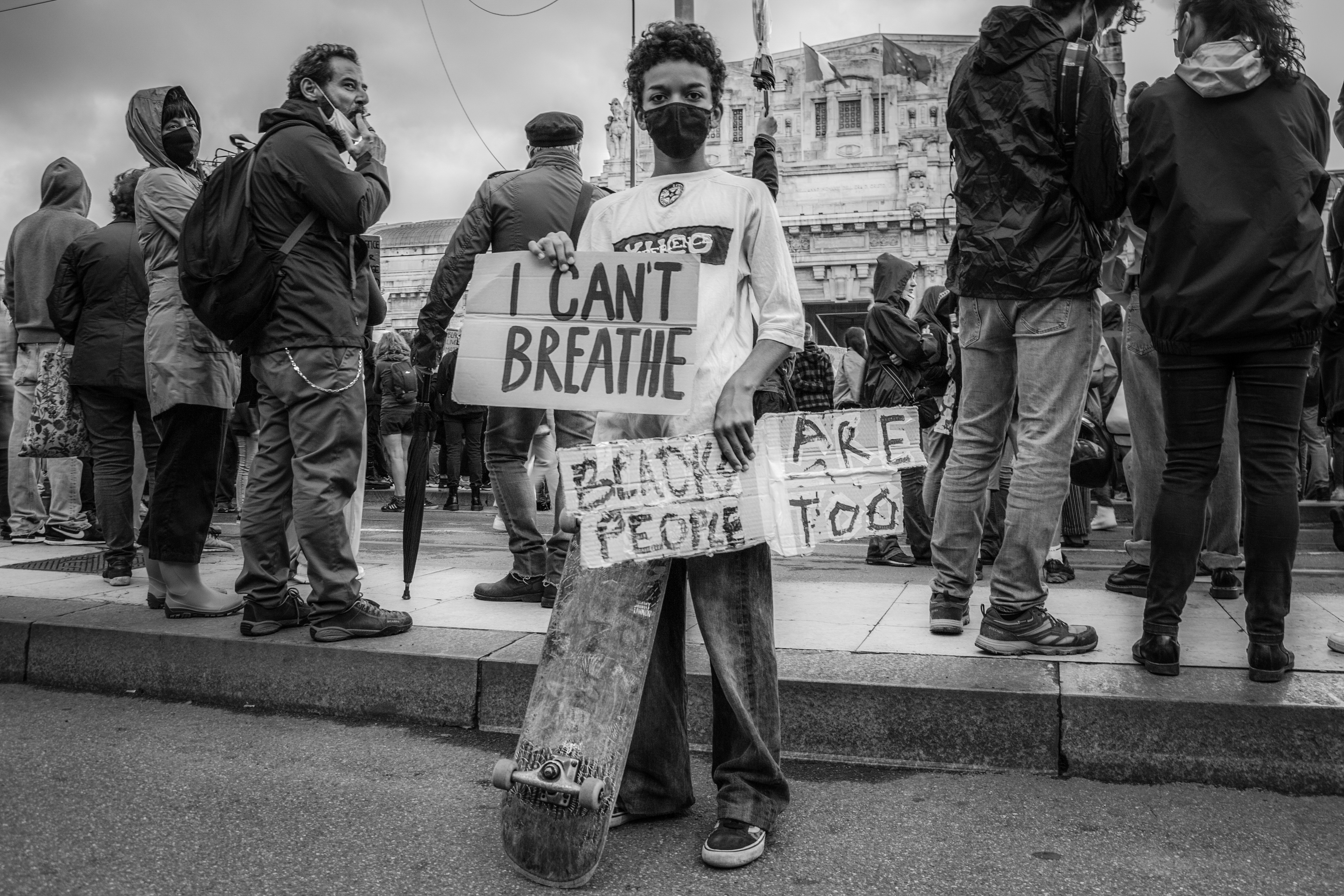 Un adolescente tiene il suo skateboard mostrando messaggi e cartelli ai fotografi (foto di Luca Covino)